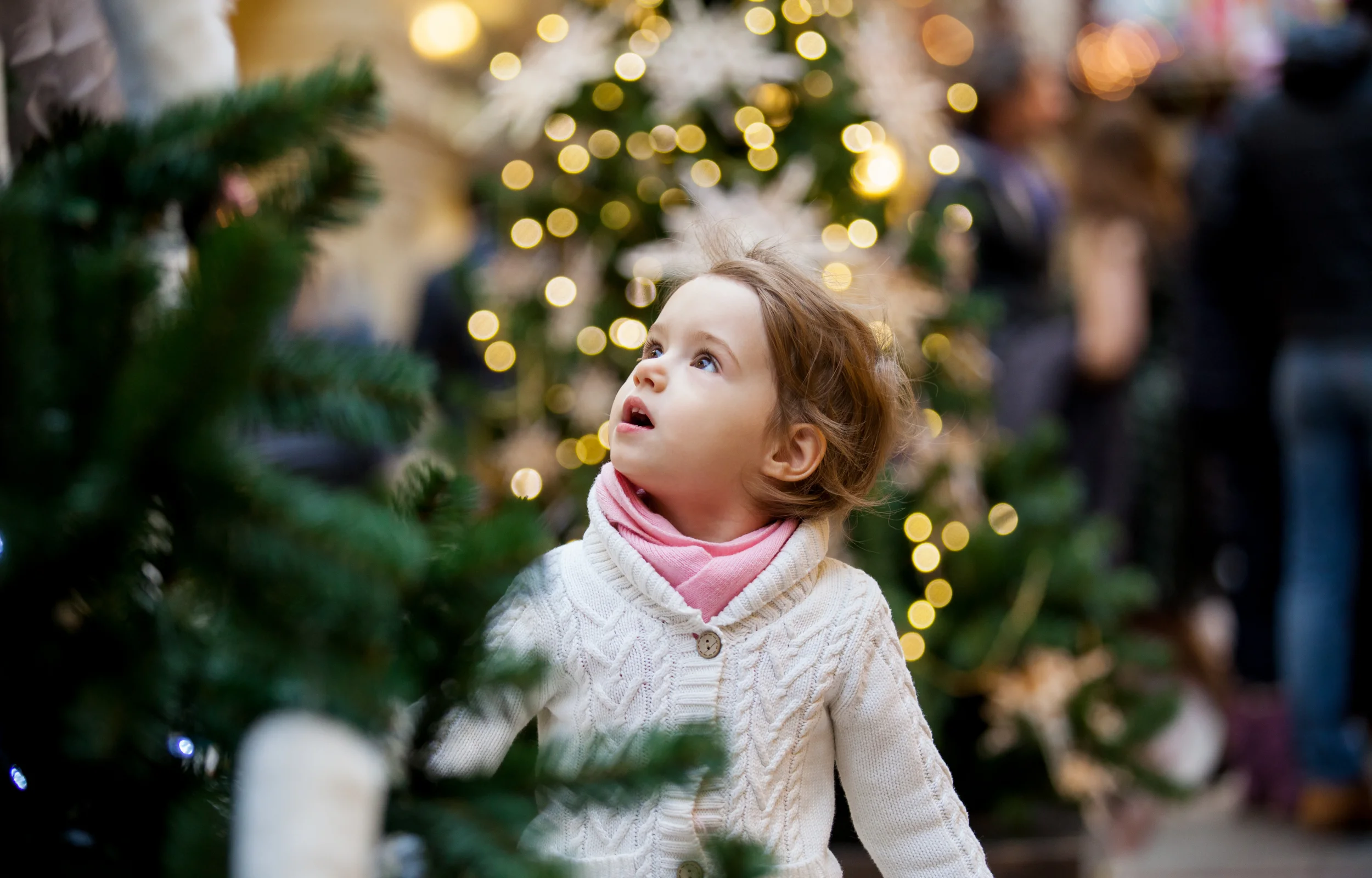 Little girl looking at the Christmas tree  