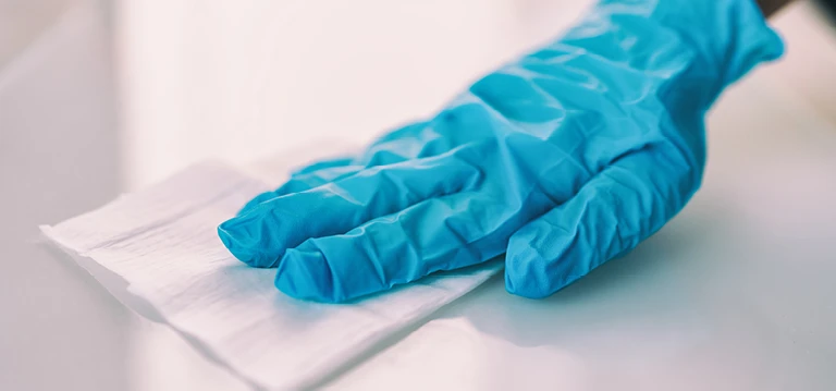 Gloved hand wiping surface