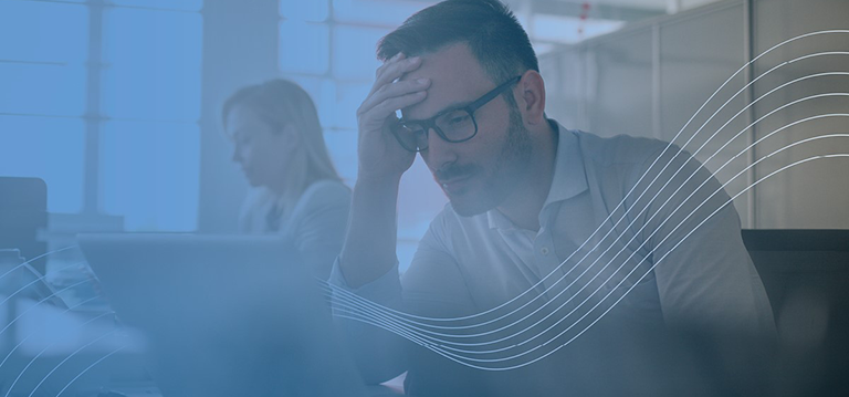 Homme dans un bureau qui semble avoir mal à la tête