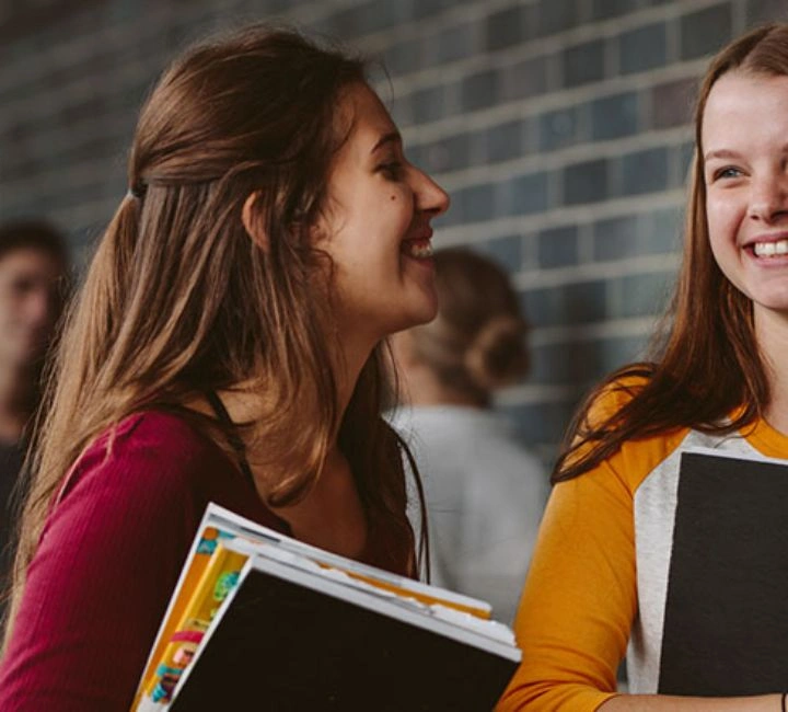 school girls laughing with books