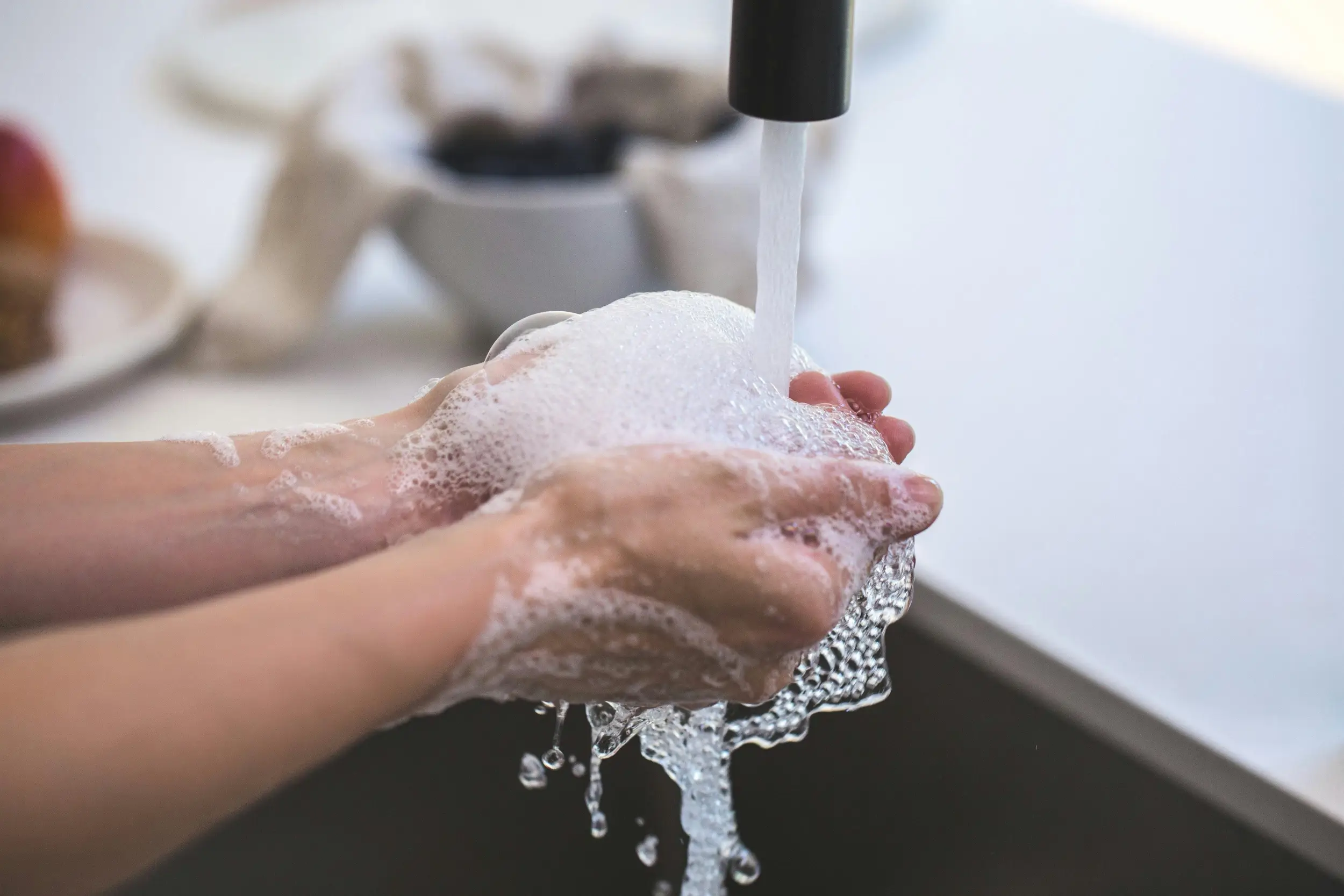 persona lavándose las manos en el baño