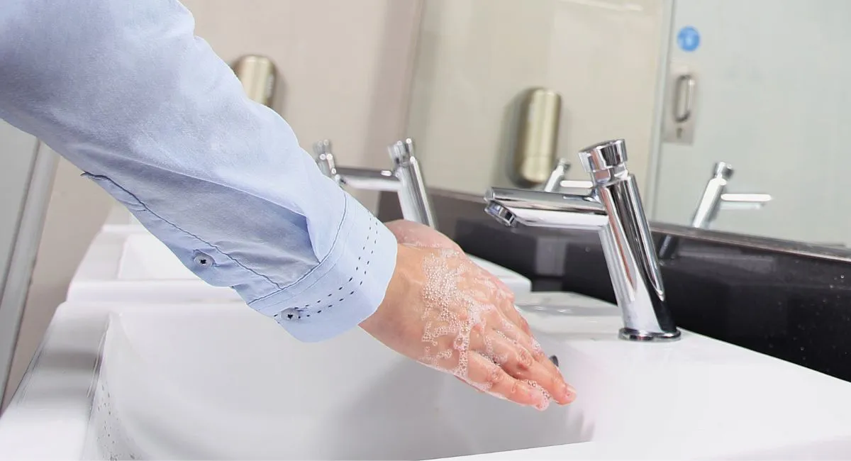 persona lavándose las manos en el baño