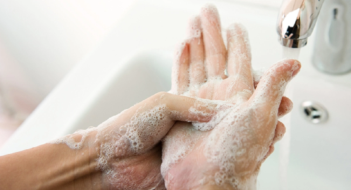 individu se lavant les mains avec du savon