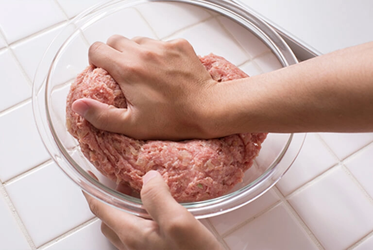 Hand handling meat